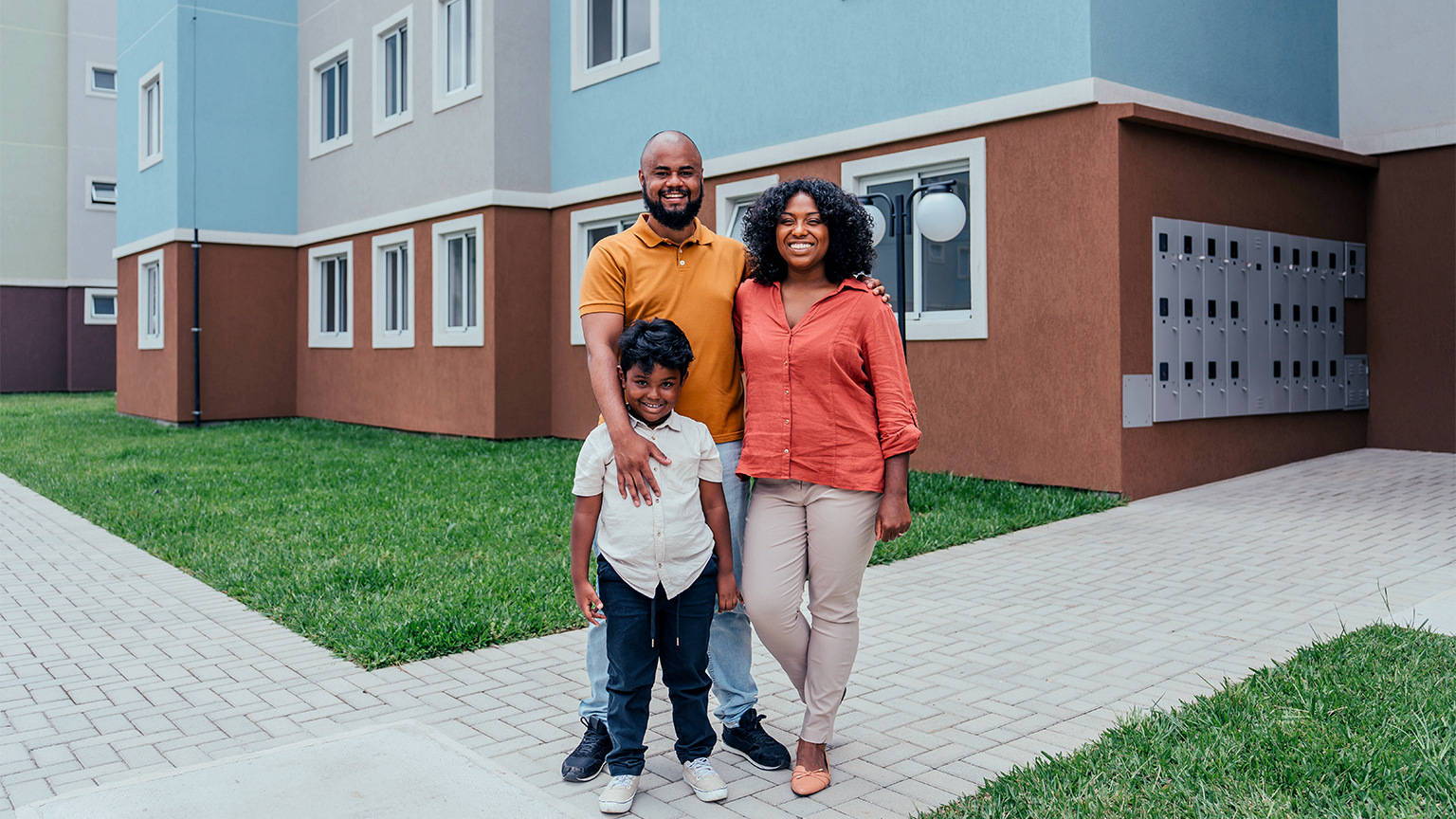 Portrait of a happy family in front of their new apartment