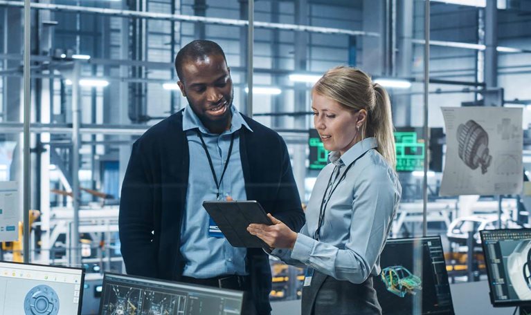 Car Factory Office: Female Engineer Talks with Male Scientist, Use Tablet Computer to Design Production Conveyor for Advanced Power Engines. Automated Robot Arm Assembly Line Manufacturing Vehicles