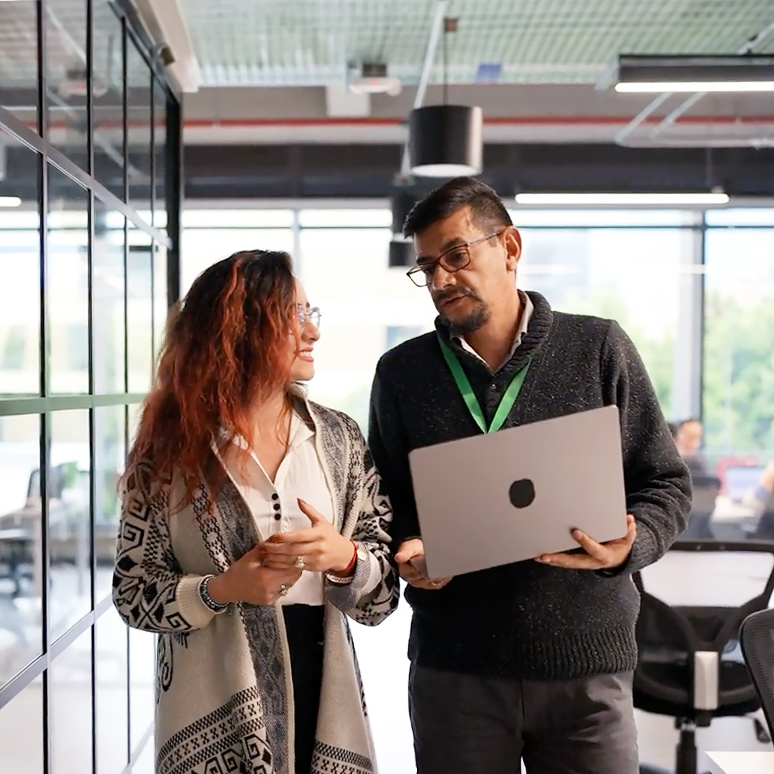 Coworkers talking while walking through the office