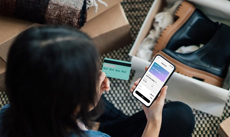Overhead View Of Young Woman Doing Online Shopping With Smart Phone