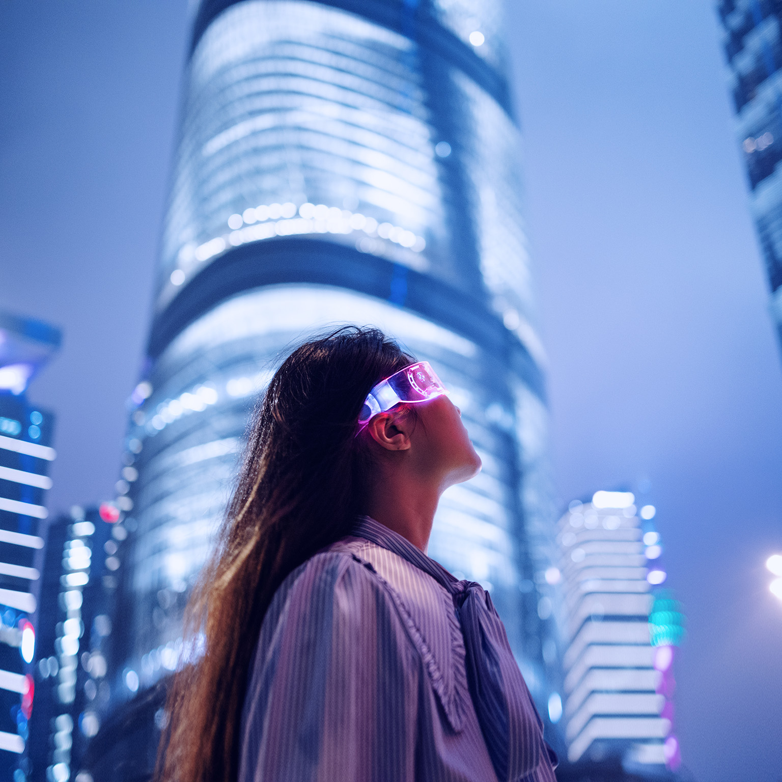 Young businesswoman standing against contemporary financial skyscrapers in the downtown financial district - stock photo