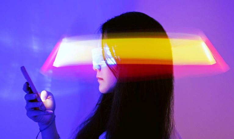 Asian woman using smartphone surrounded by beams of light