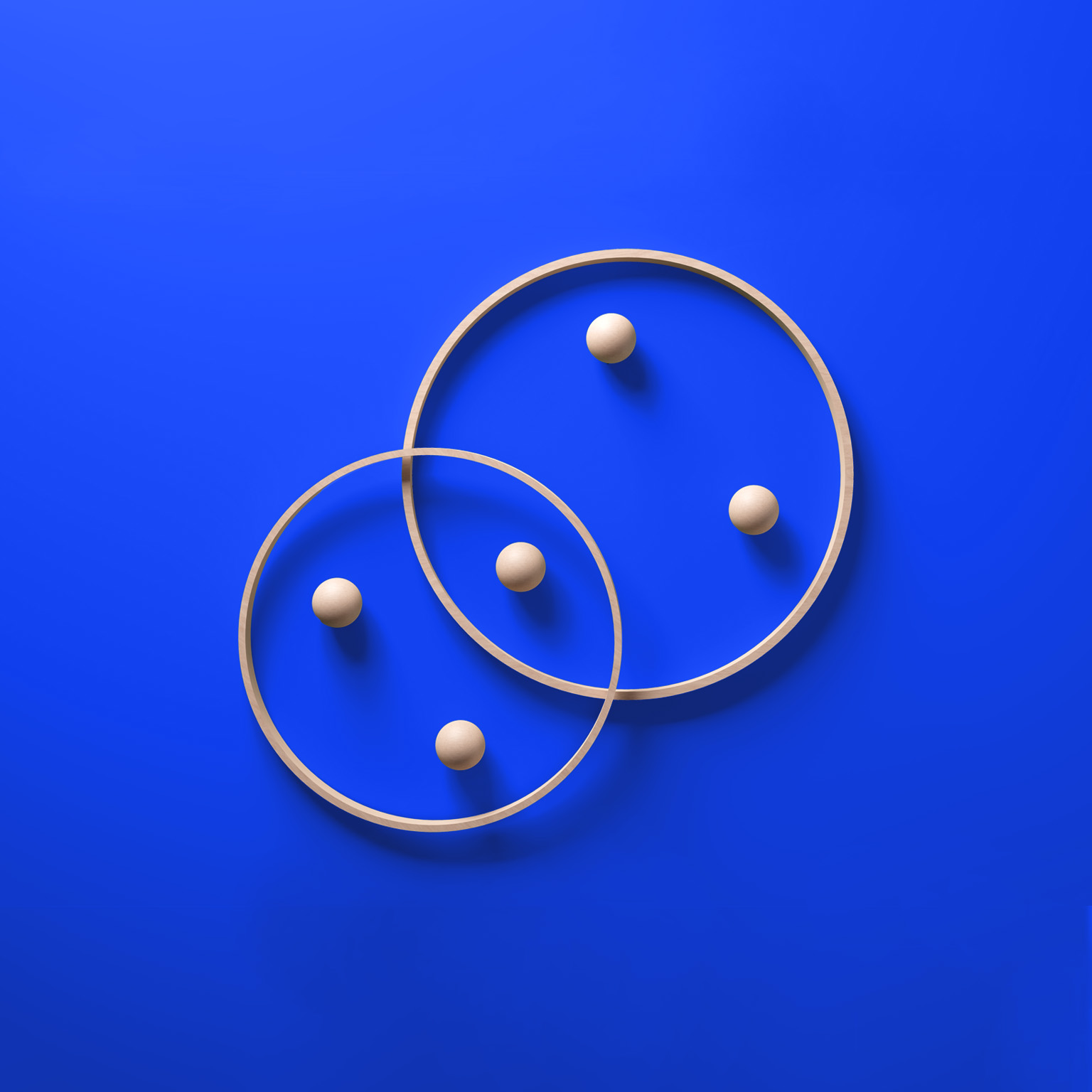 Interlocking contemporary wooden rings with embedded spheres, symbolizing a harmonious partnership, set against a vibrant blue background.