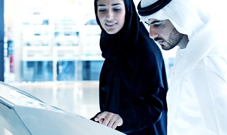 Arab family using interactive screen of digital kiosk - stock photo