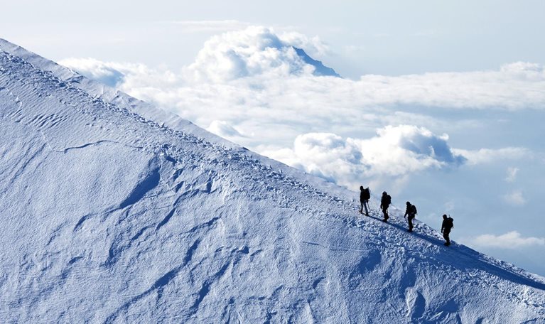 Climbers ascending on a snow mountain peak