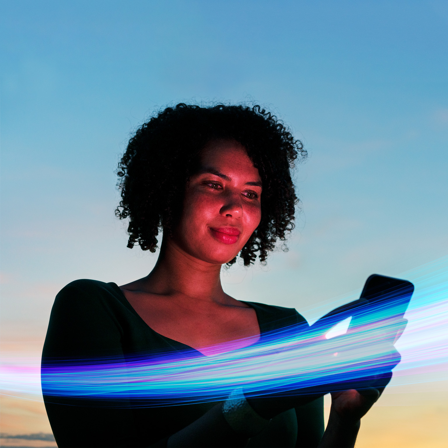 Woman using a smartphone against a vibrant blue sky backdrop, surrounded by vivid streaks of colorful light.