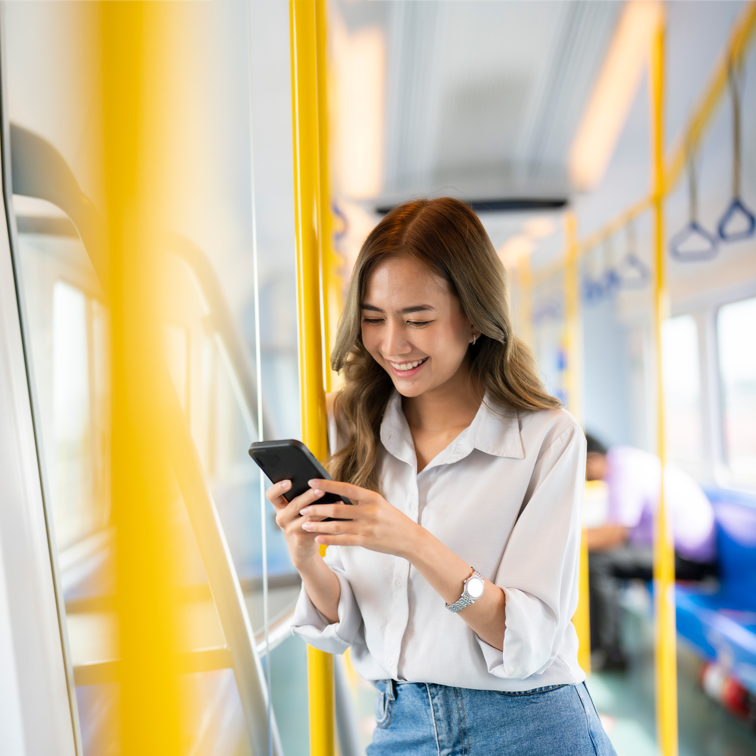 Happy young woman traveling by bus and using a smartphone. - stock photo