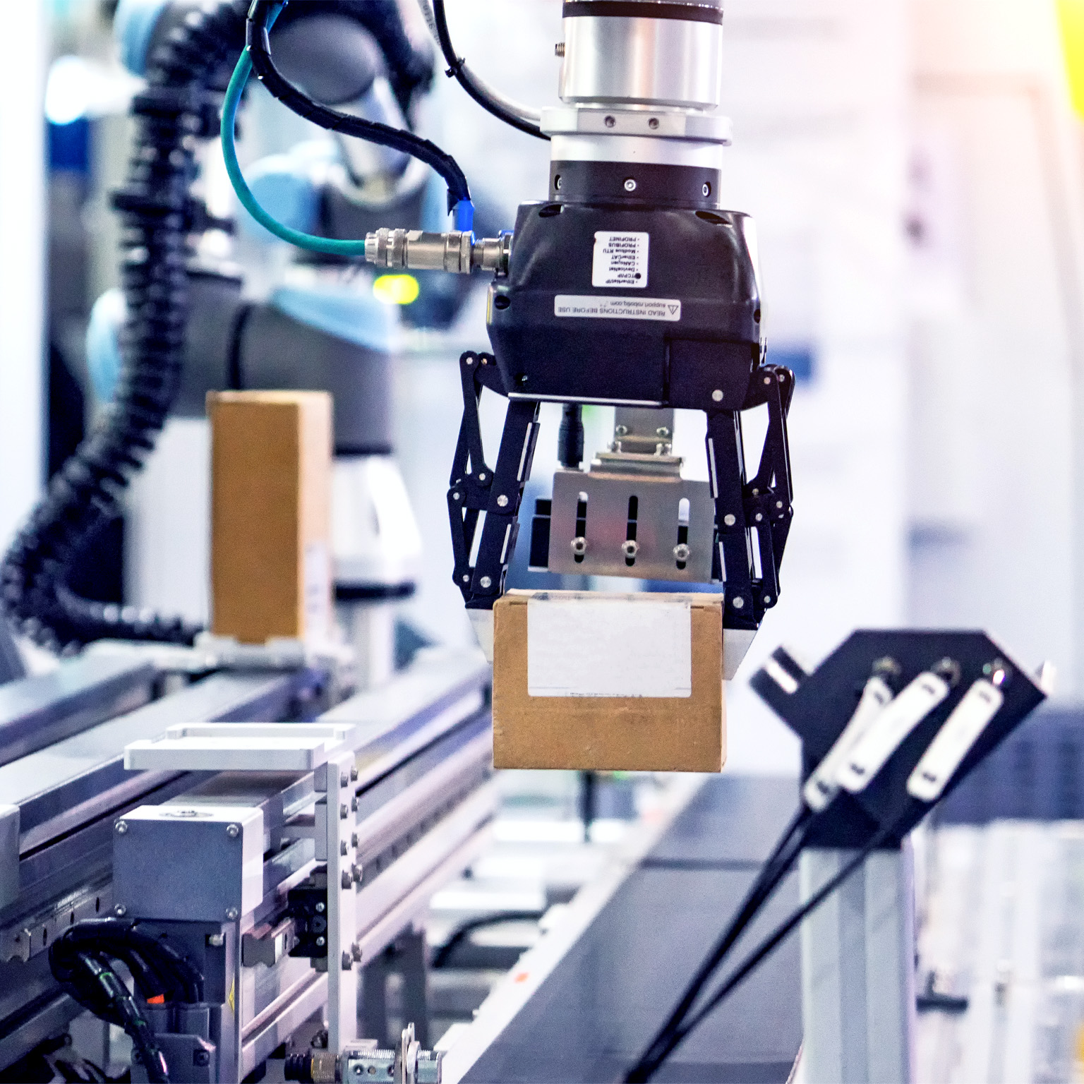 Robot picking a box in a manufacturing factory.