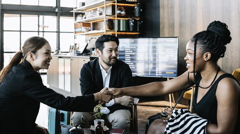 Three people greeting each other