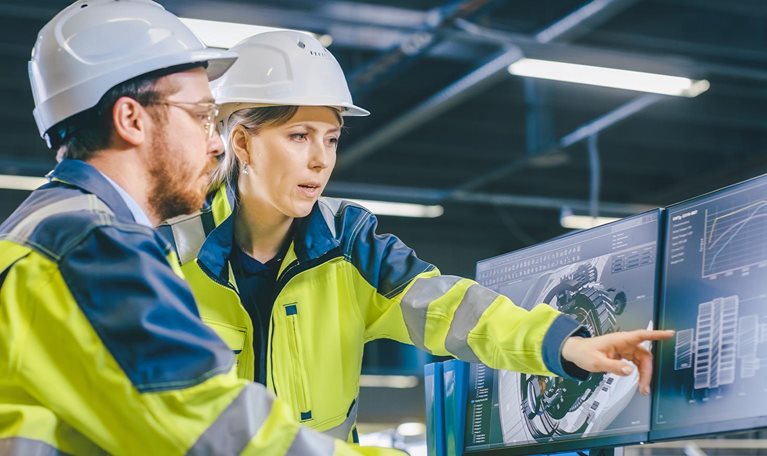 Inside Factory Male Mechanical Engineer and Female Chief Engineer Work Together on the Personal Computer, They Discuss Details of the 3D Engine Model Design.