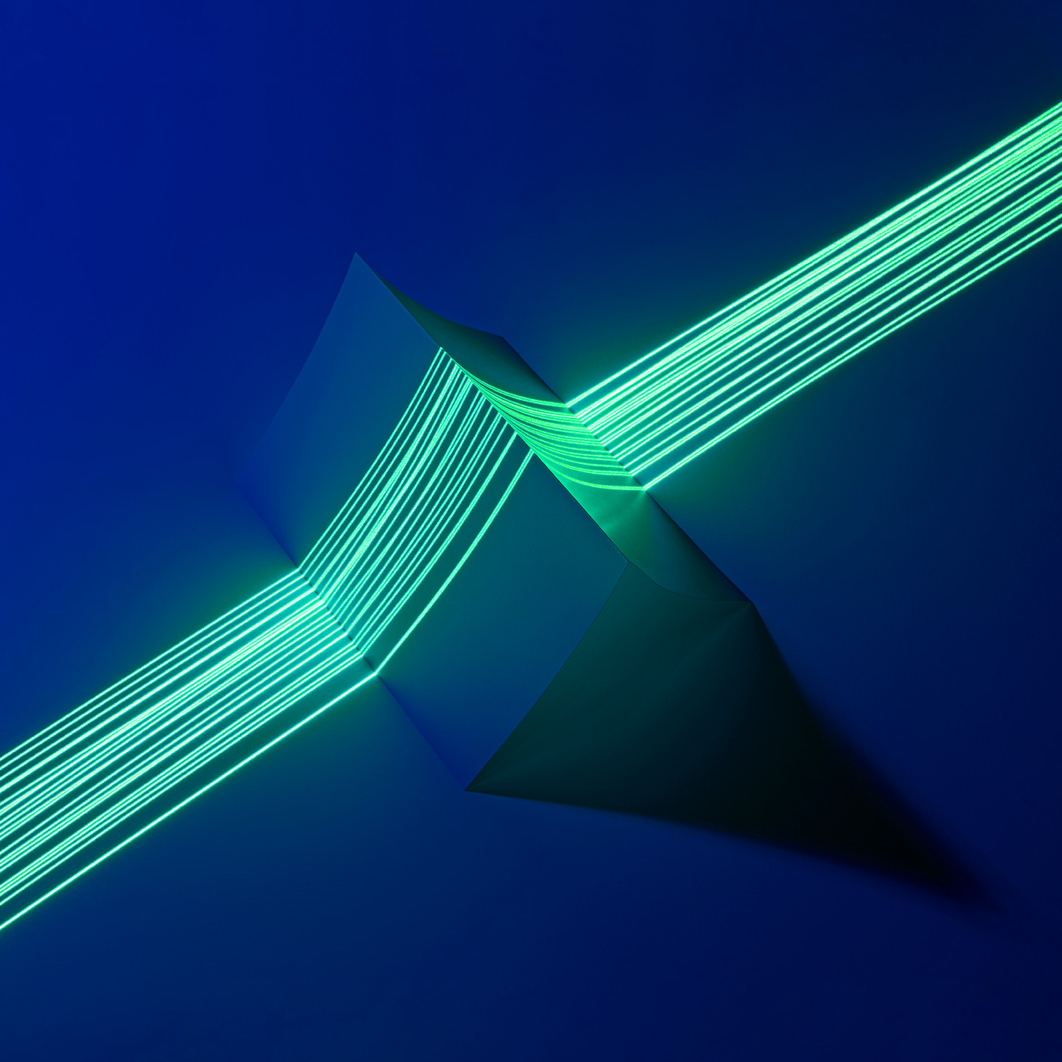 Image of multiple green laser lines coming together to precisely measure a triangle shaped object.