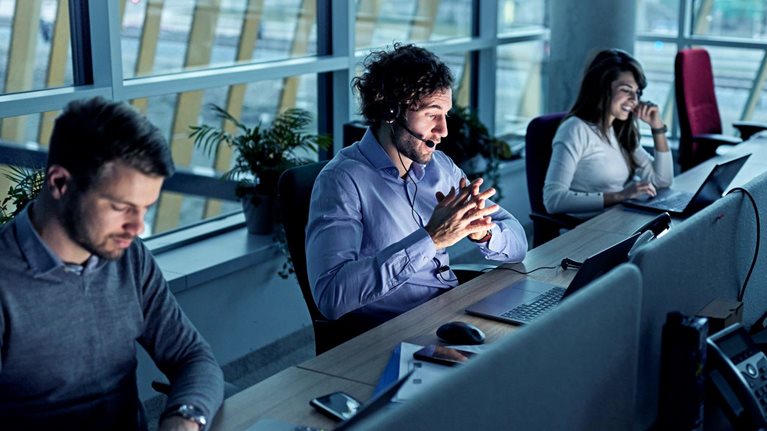 Business people working on laptops in a call center