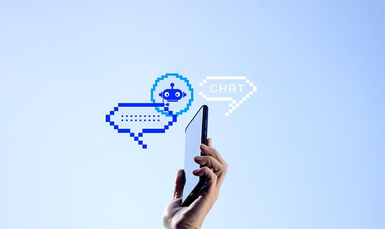 A hand holding a mobile phone with two pixelated chat bubbles and an AI bot icon against a clear blue sky.