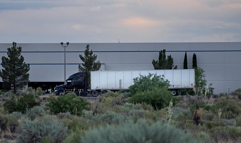 Semi truck on highway in front of a building near the US/Mexico border