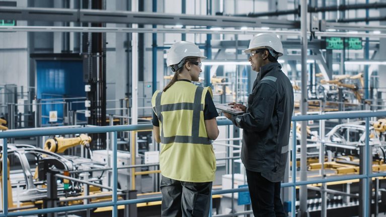 Two workers talking in a factory