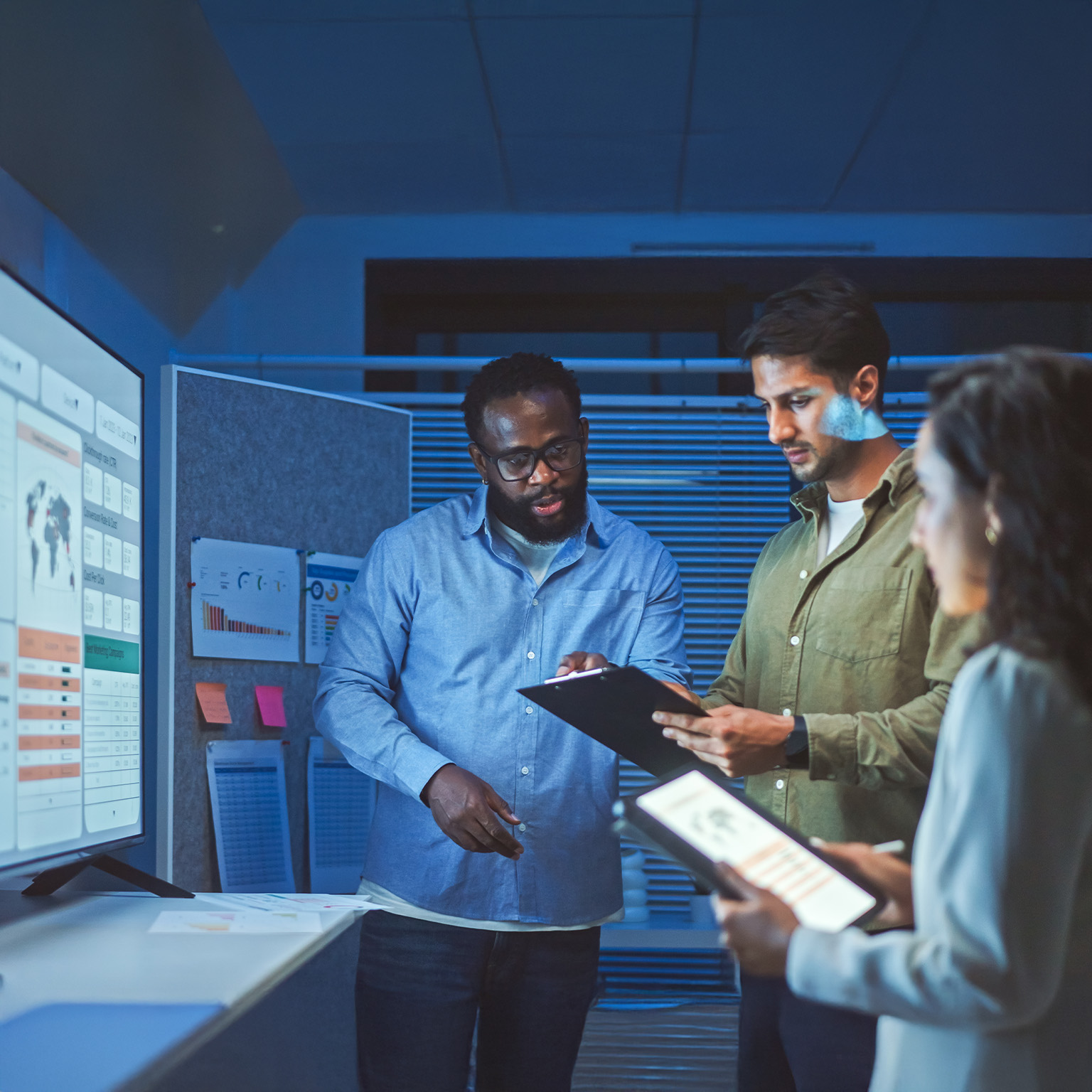 A team of multiethnic developers is meeting to review the data analysis of marketing from social media platforms.