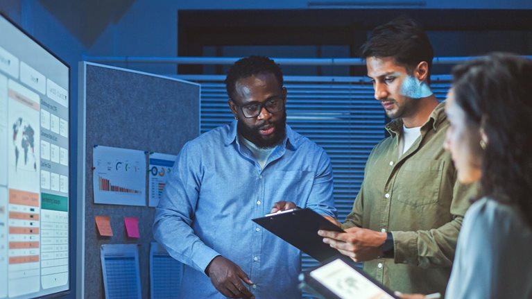 A team of multiethnic developers is meeting to review the data analysis of marketing from social media platforms.