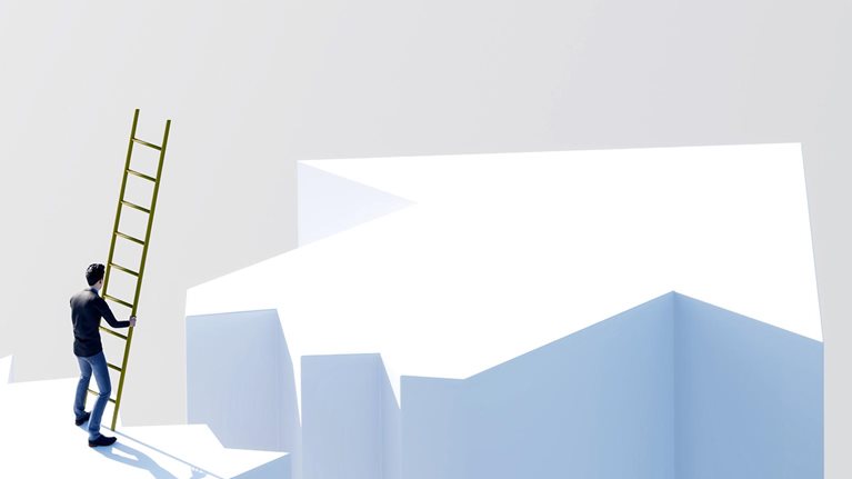 Person holding a ladder while standing near the edge of a gap between elevated surfaces.