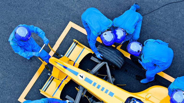 image of pit crew fixing a race car