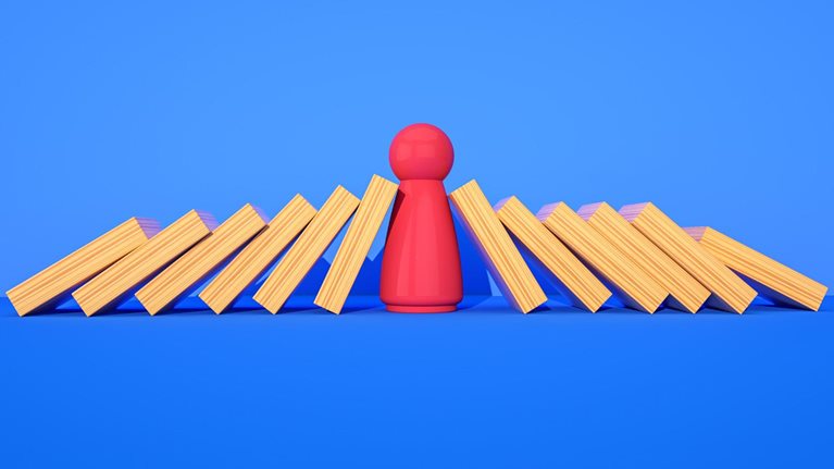 Red wooden model balanced between wooden bars