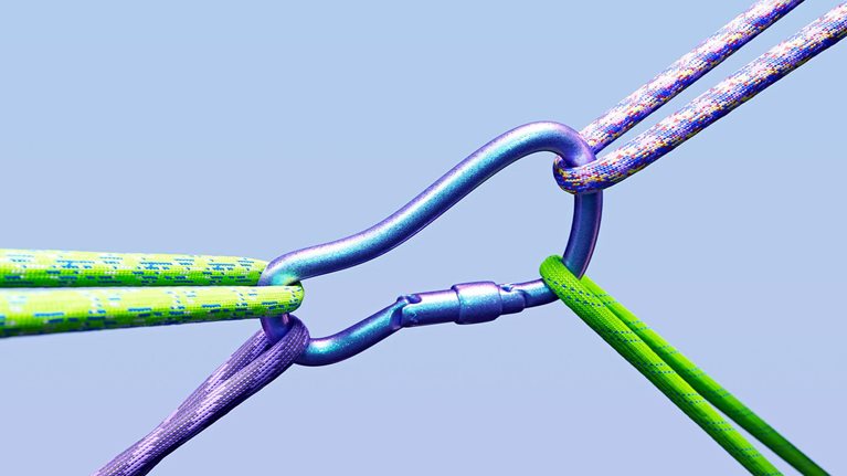 A closeup image of a carabiners being pulled in multiple direction by ropes.