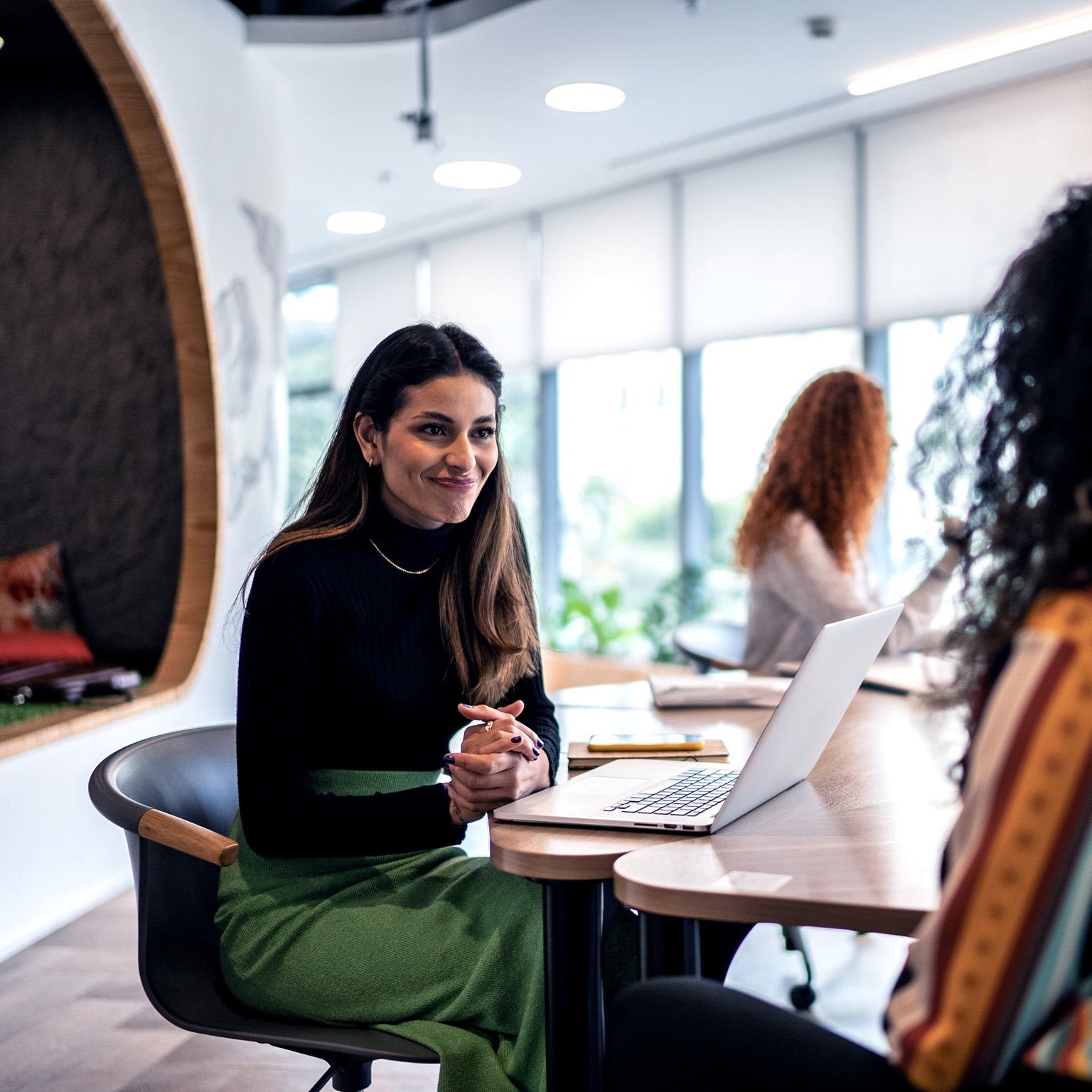 A woman interviewing a candidate with an enthusiastic expression on her face.
