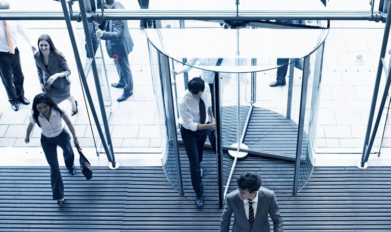 Employees entering their office though multiple doors in the lobby