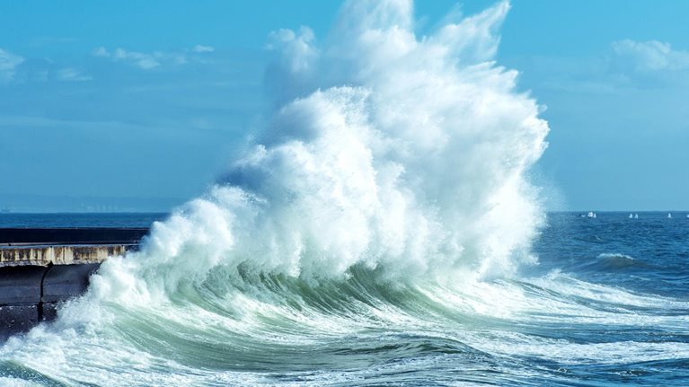 Big waves breaking against a seawall on the coast