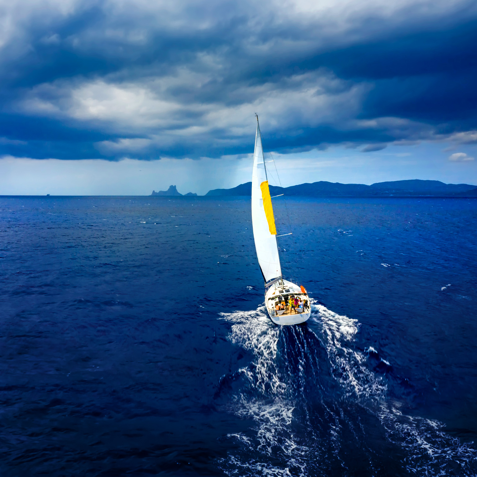 Aerial view of a yacht in a storm with a dramatic sky