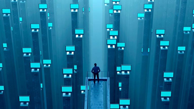 Man watching abundance of glowing computer monitors