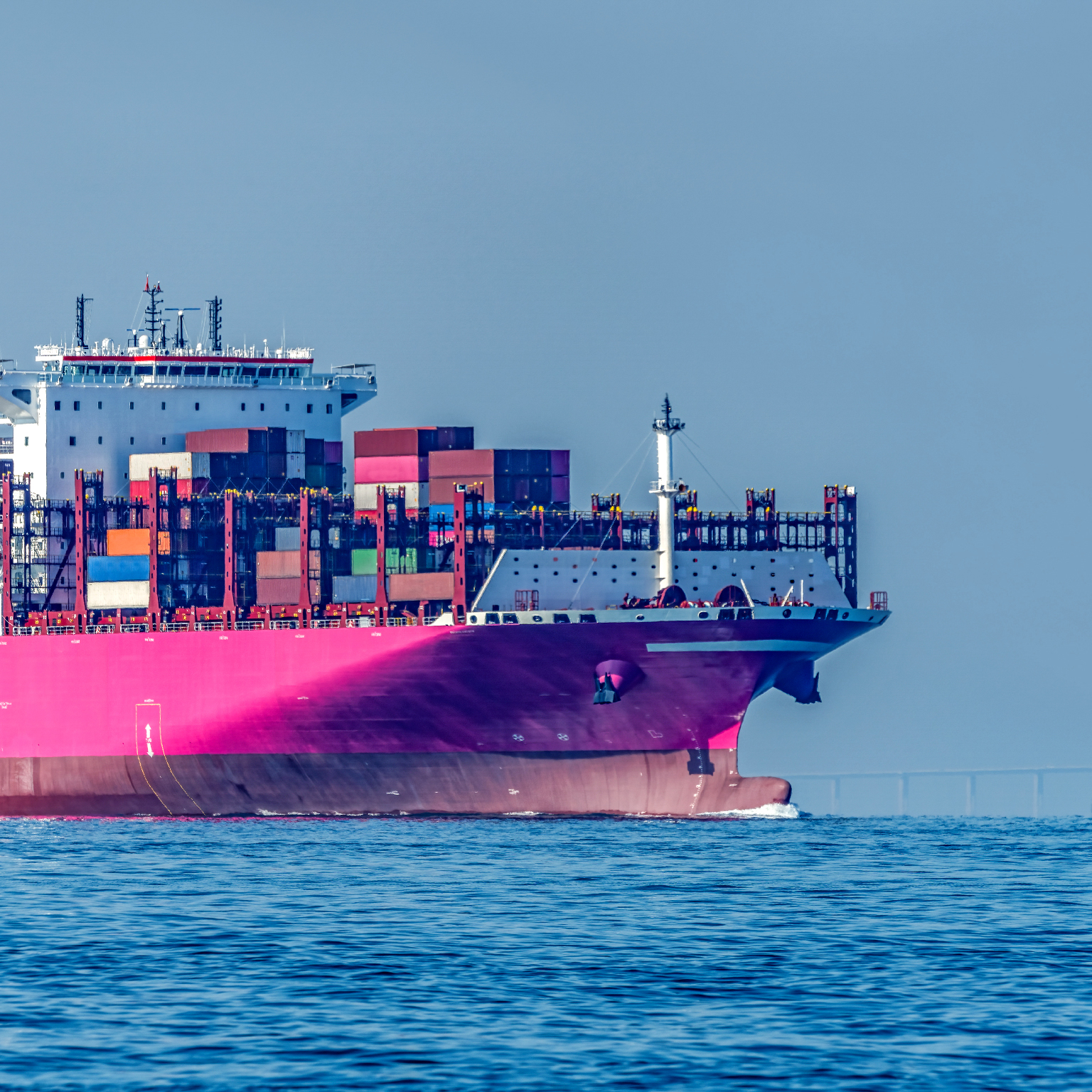 A Pink Container Ship is Sailing on the Sea