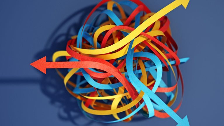 Tangled paper cut blue, yellow and red tapes with arrows pointing different ways
