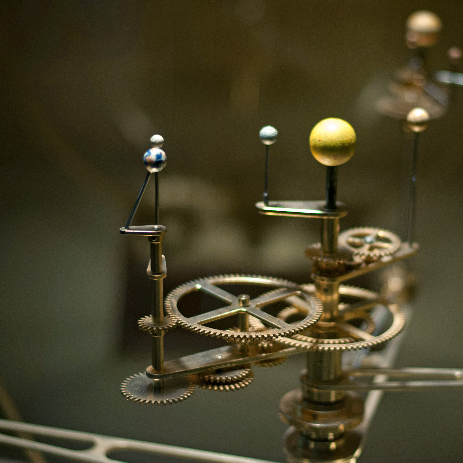 A mechanical device illustrating how the solar system revolves.