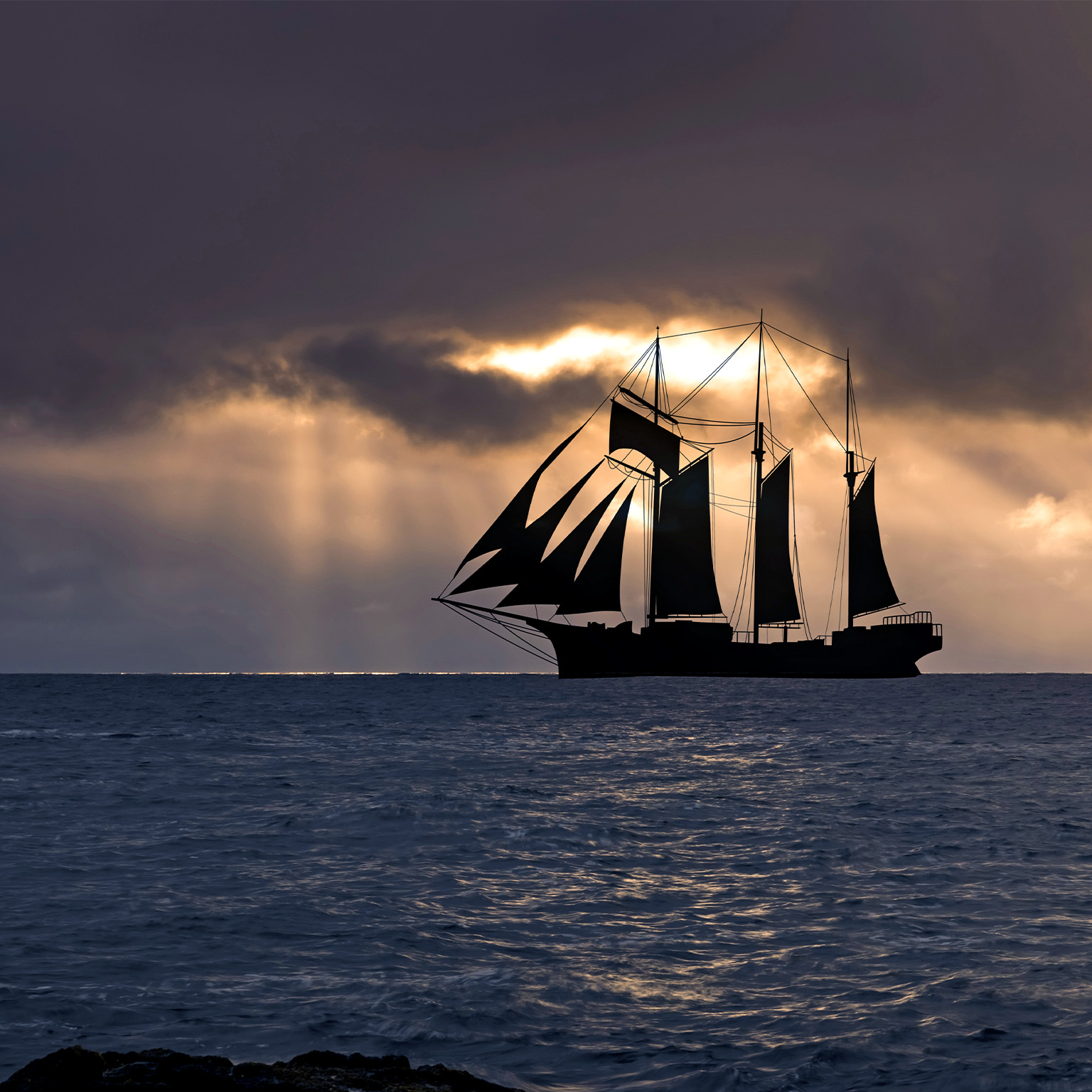 Image of a sailboat at sunset in a stormy sea.
