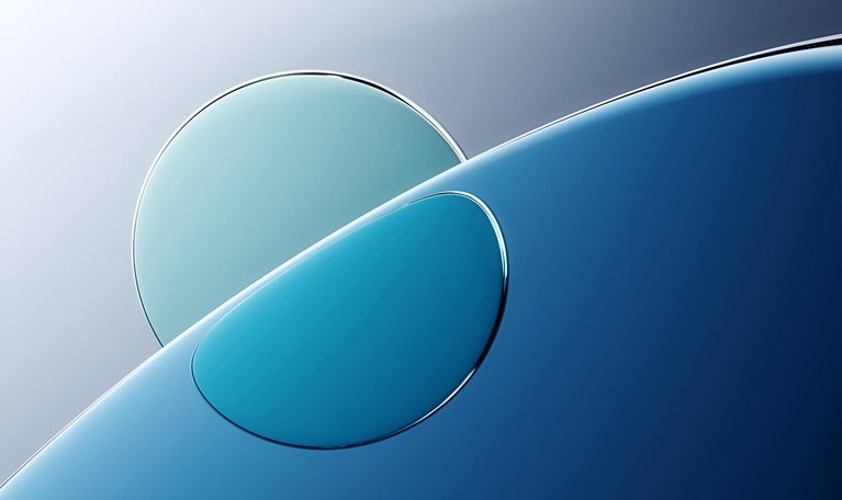 An abstract image of a curved, shiny surface of water with a lighter circle behind and refracted through it.