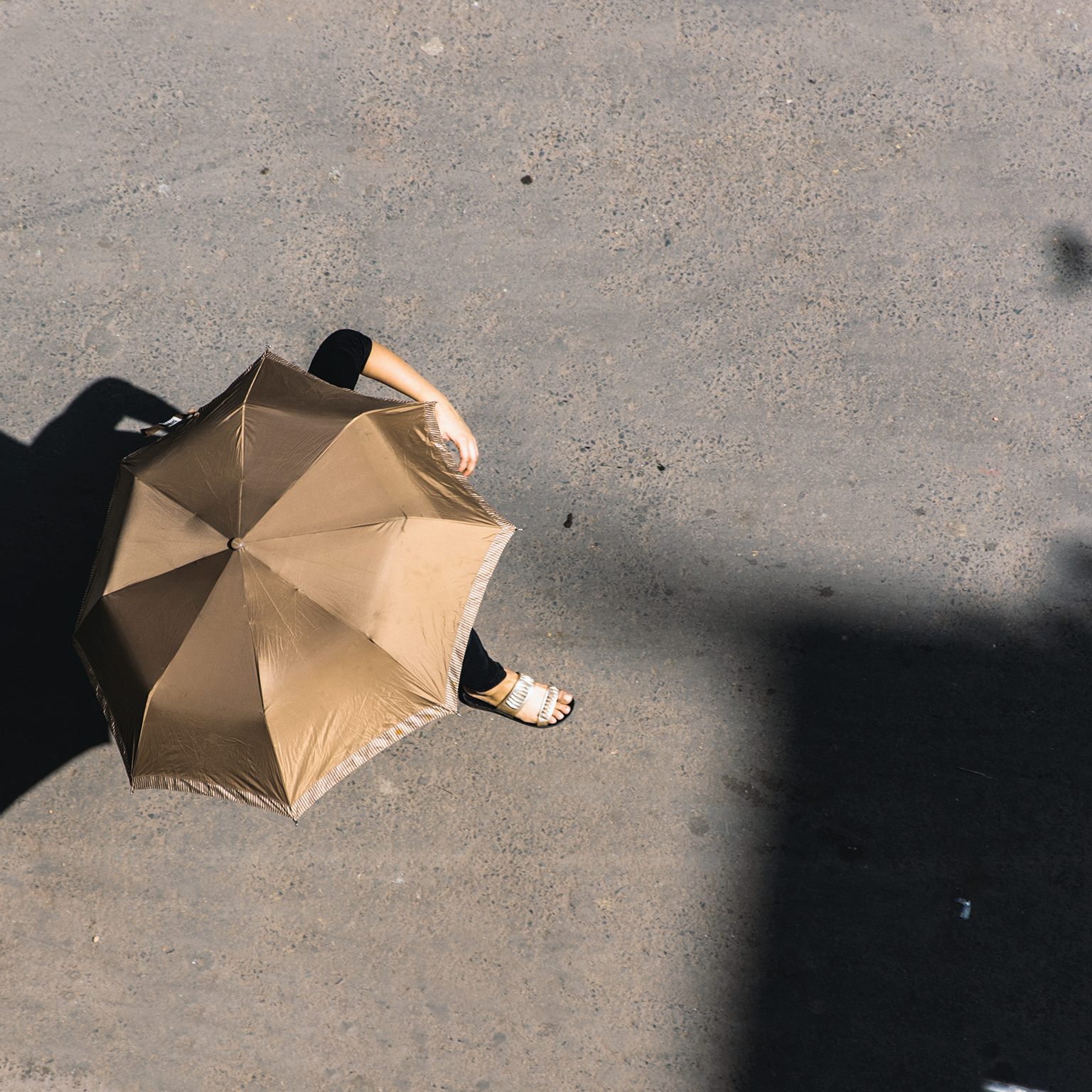 Woman using umbrella as shade from the sun