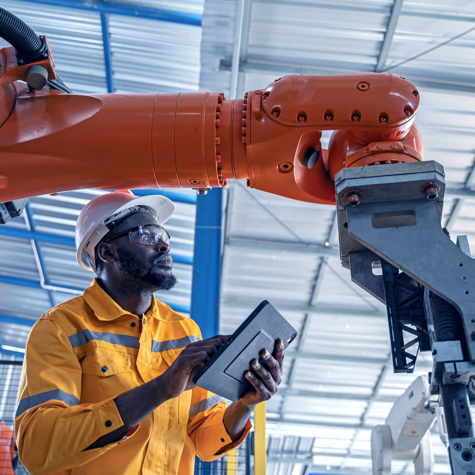 Engineer working with machinery at industrial manufacturing plant.