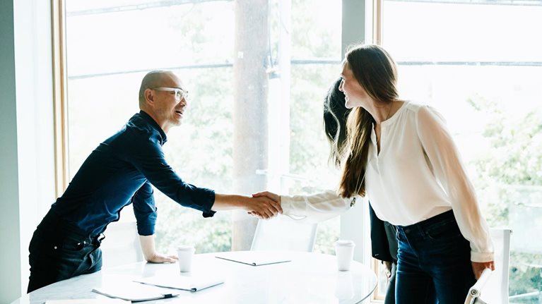 Businesswoman shaking hands with client before meeting