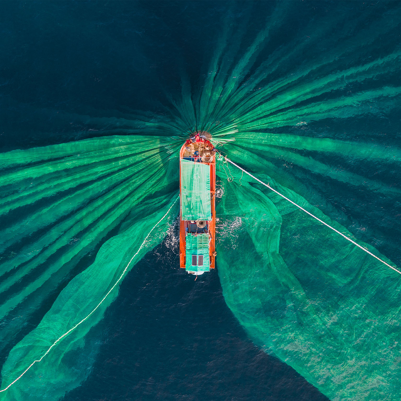 Drone photograph looking down on a fishing trawler catching anchovies, Vietnam