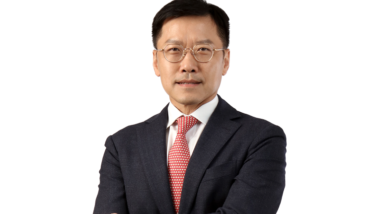 Photograph of Lee Yuan Siong in a dark suit and red tie against a white background