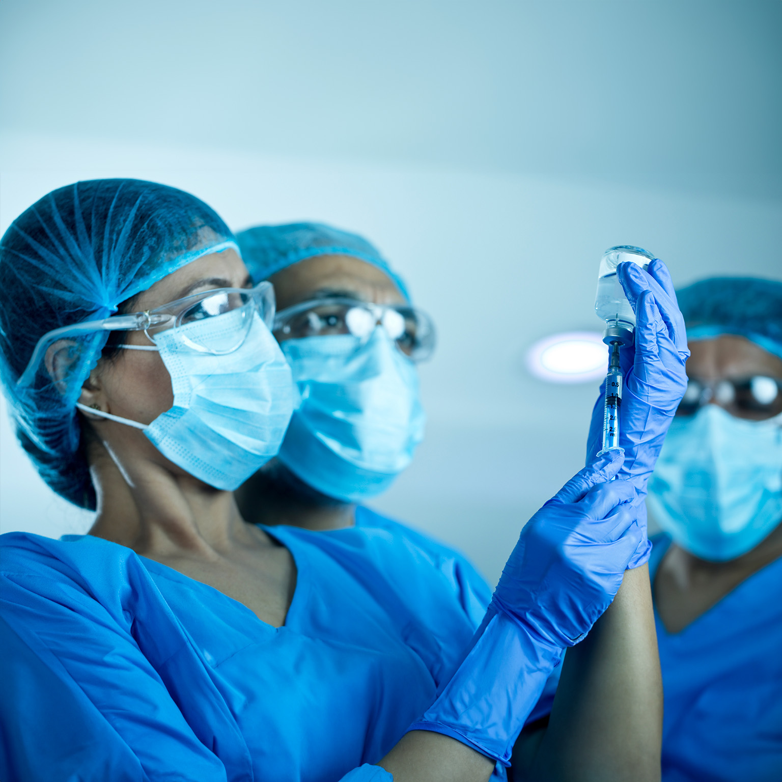 Doctors team preparing injection with COVID-19 vaccine - stock photo