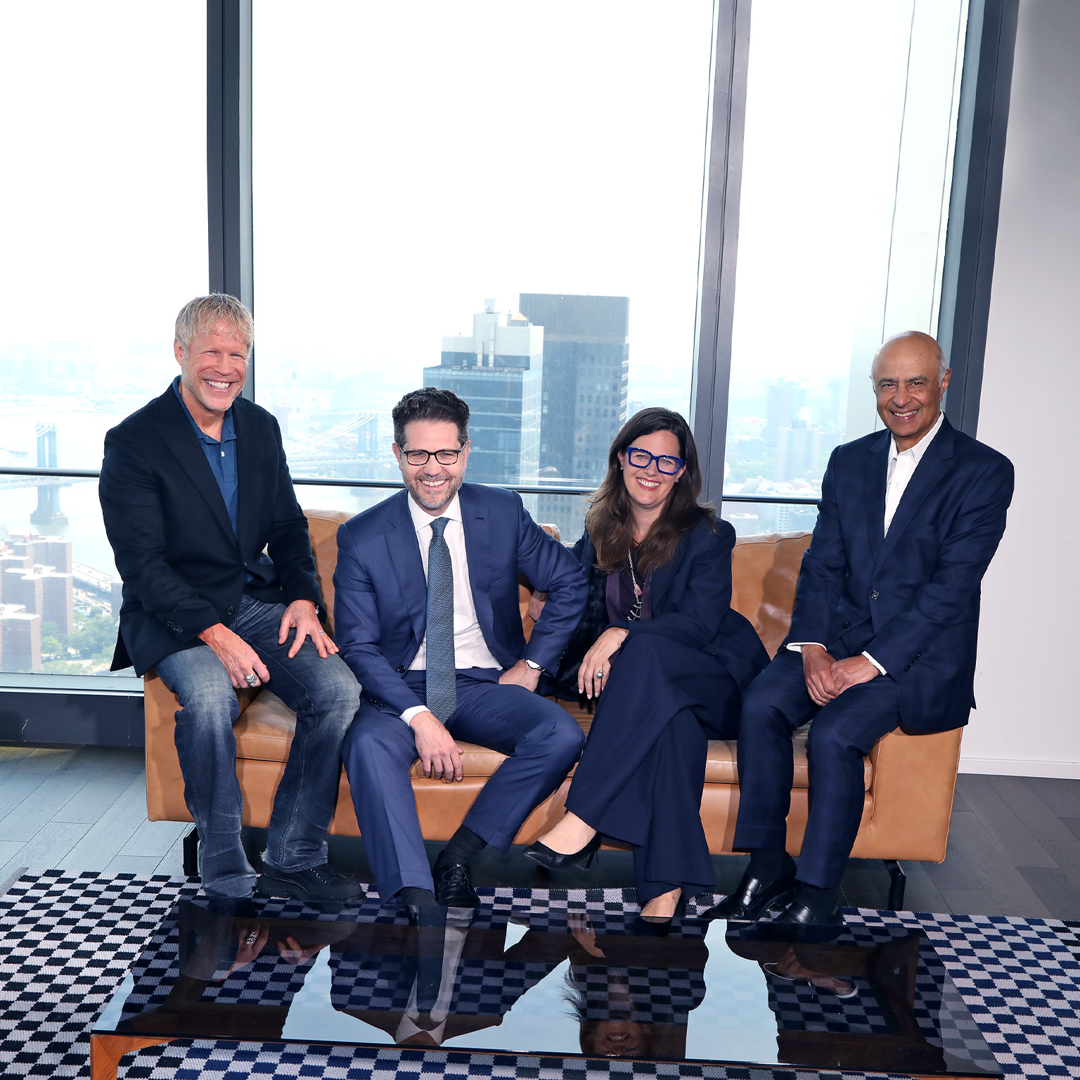 Photograph of Carolyn Dewar, Kurt Strovink, Scott Keller, and Vik Malhotra sitting together in a modern office.