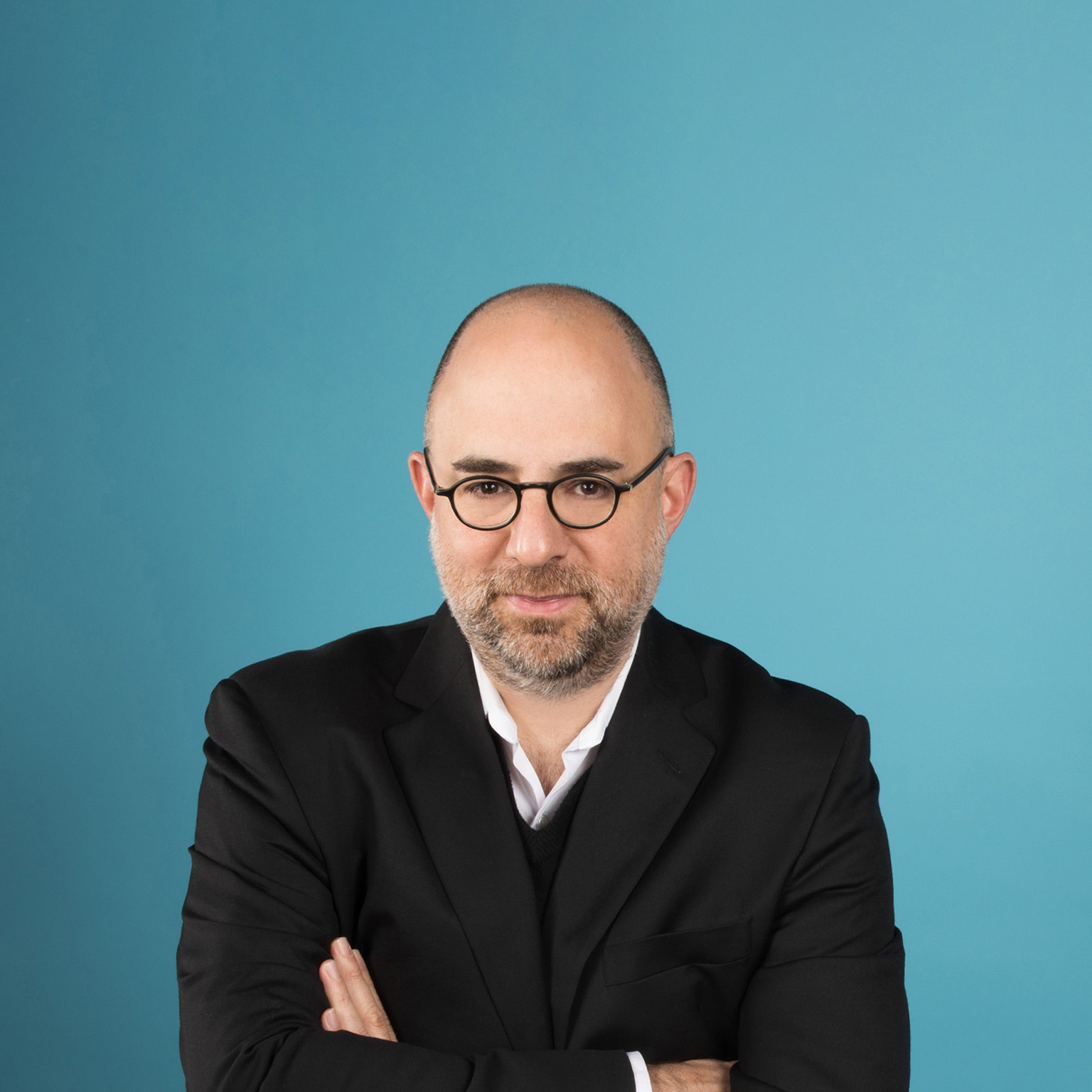 Portrait of Moshik Temkin in front of a teal backdrop.