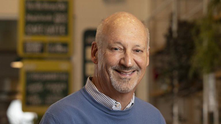 Portrait of Ron Shaich with a warm office setting blurred in the background.
