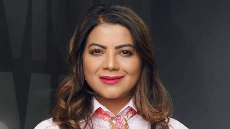 Jeniffer Ramnath with a light smile and wearing a pink top and patterned scarf.