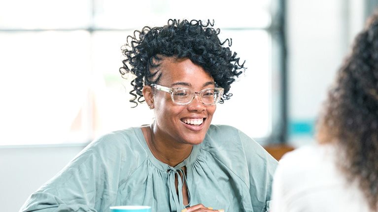 Cheerful woman meeting female friend for coffee