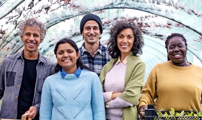 Group portrait of garden center workers standing together with plant crates