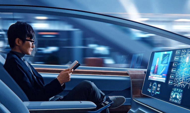 Futuristic Concept: Handsome Stylish Japanese Businessman in Glasses Reading Notebook and Watching News on Augmented Reality Screen while Sitting in a Autonomous Self-Driving Zero-Emissions Car.
