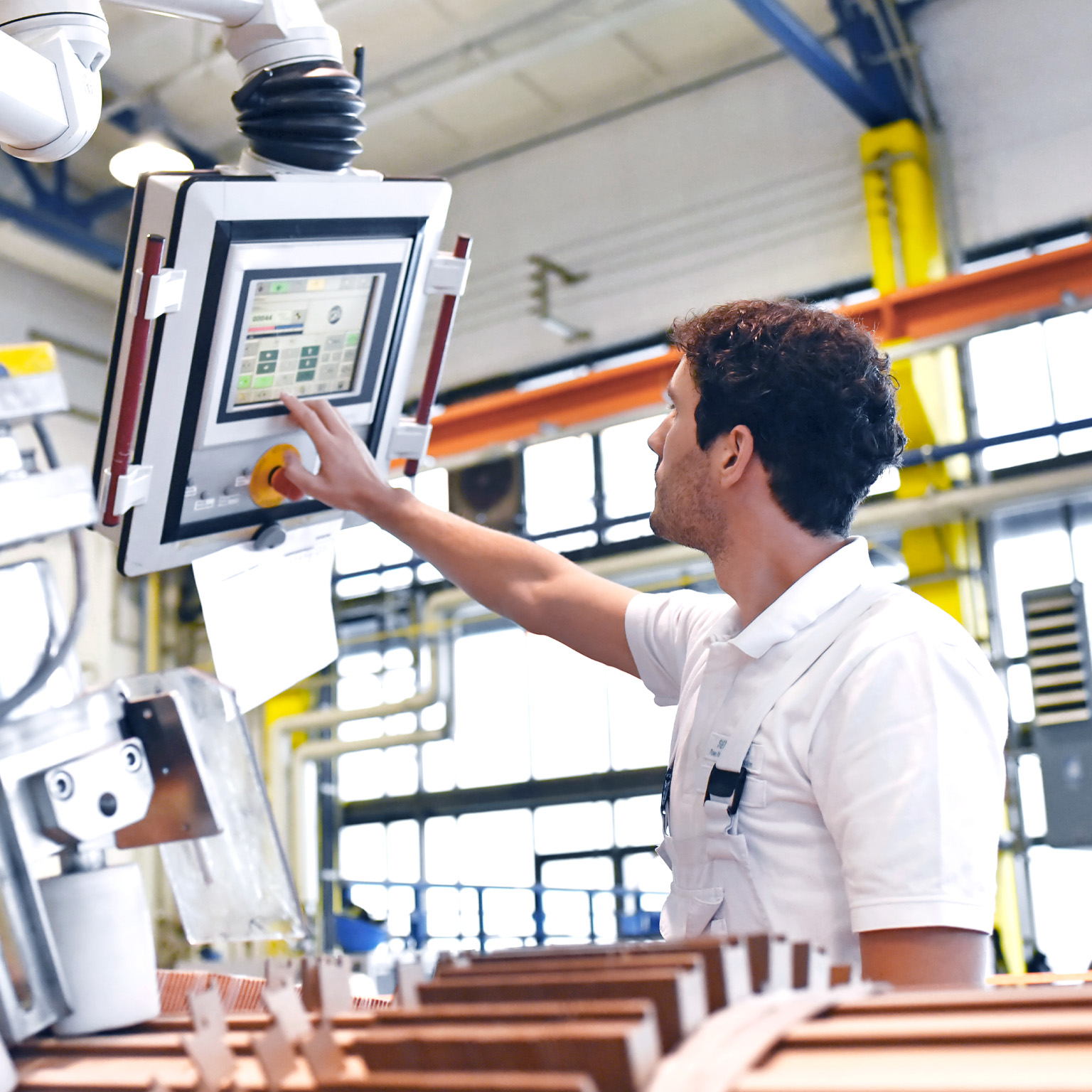 Young mechanical engineering workers operate a machine for winding copper wire