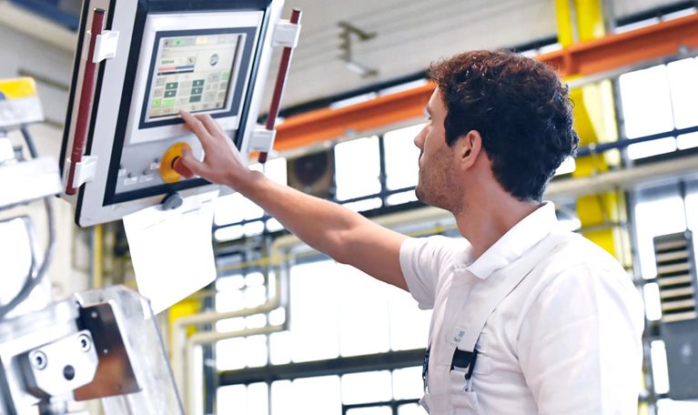 Young mechanical engineering workers operate a machine for winding copper wire
